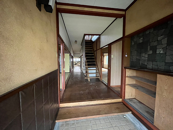 木造二階建て住宅の一階の内部。玄関の先には廊下が下屋まで一直線に伸び、玄関を上がった先は二階へ行く為の階段があります。廊下の左右には和室や、洋室等の各部屋へと繋がっています。