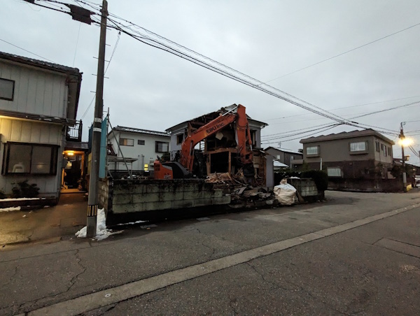 富山市のショベルカーで木造住宅を解体工事している所