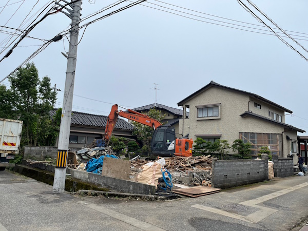 富山市の空き家をユンボで解体工事している所。